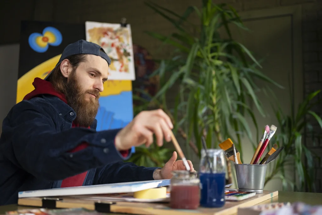 thoughtfully holding a paintbrush