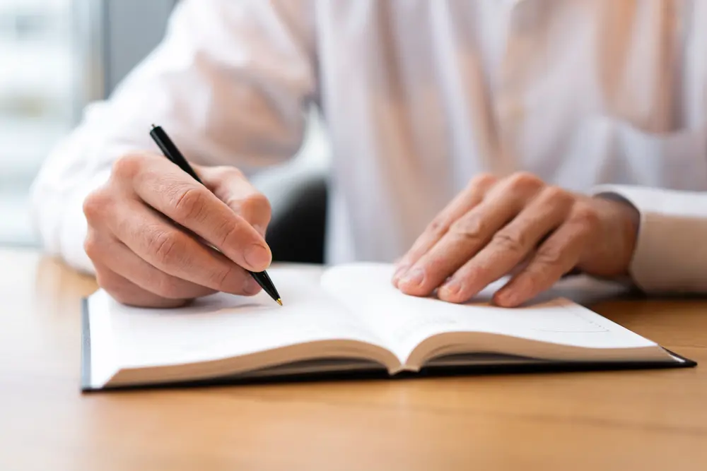 Hands writing in notebook